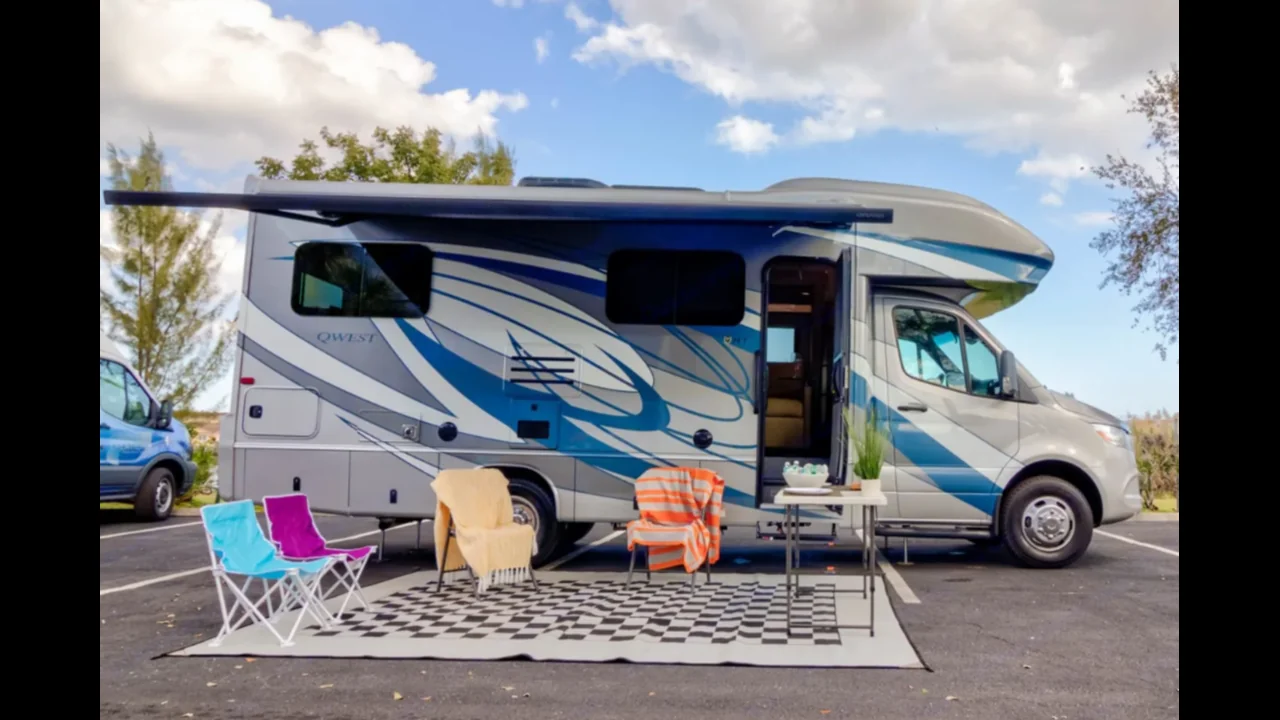 Rusty’s blue Entegra Qwest with its awning extended and outdoor seating
